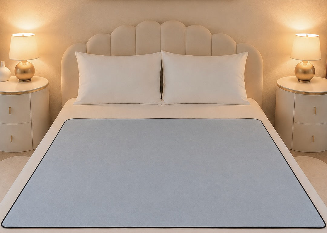 Aquamarine organic cotton Venus Mat on queen bed — soft blue-grey waterproof sex mat lies flat edge to edge, PFAS-free, made in the USA