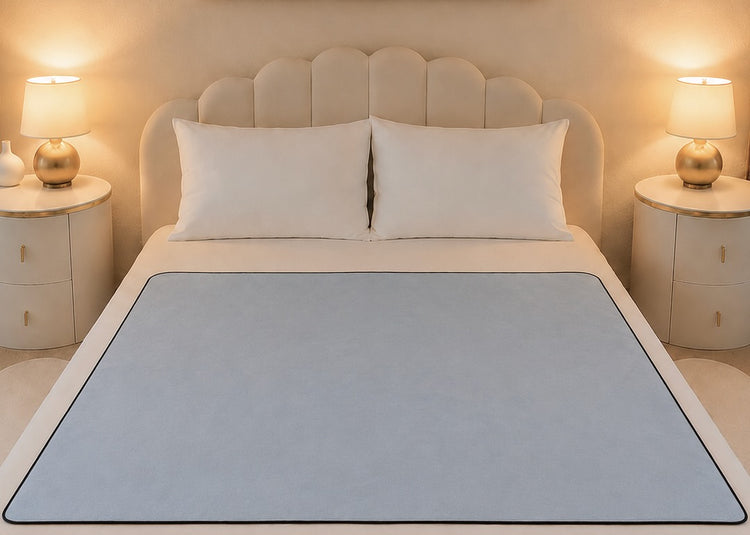 Aquamarine organic cotton Venus Mat on queen bed — soft blue-grey waterproof sex mat lies flat edge to edge, PFAS-free, made in the USA