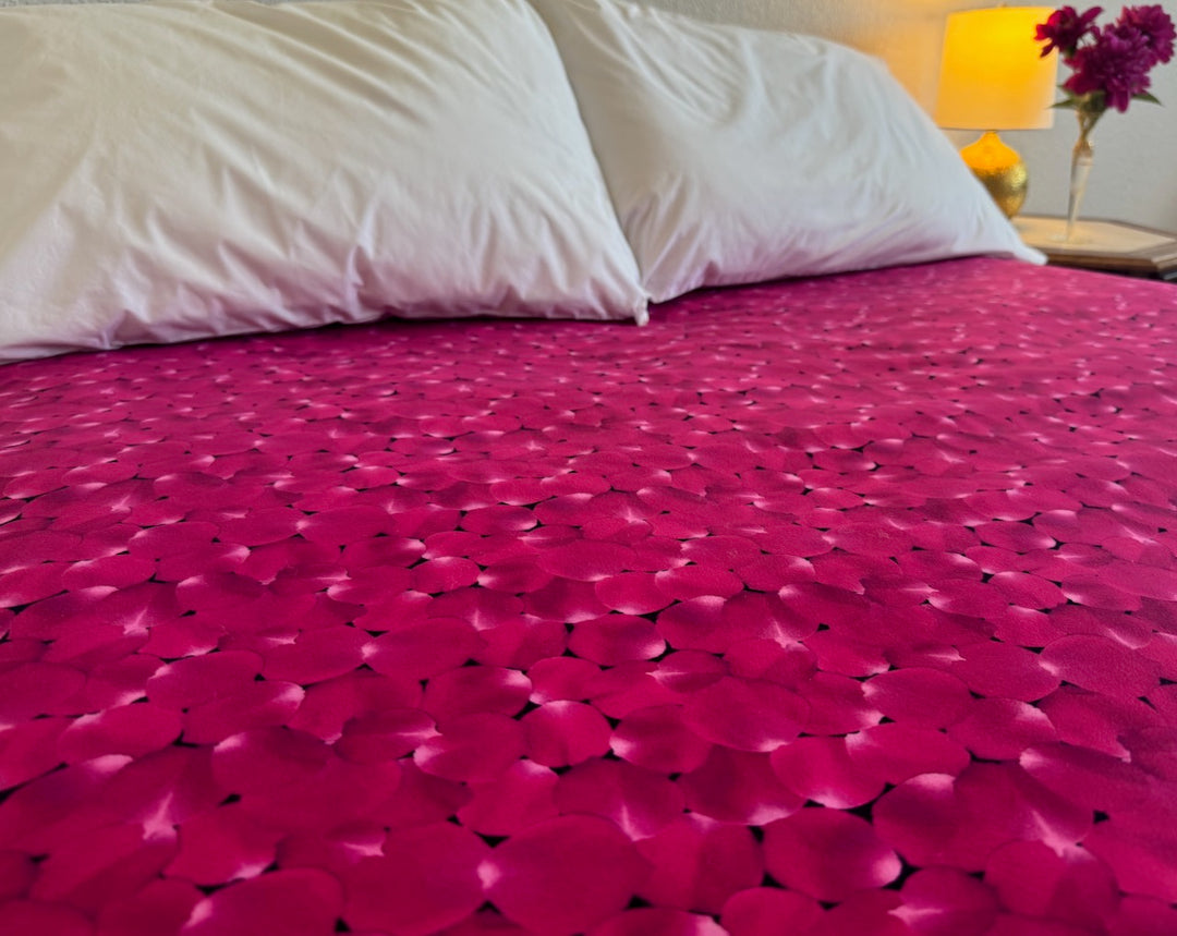 Hot pink and lilac rose petals scattered everywhere on this guaranteed waterproof bed mat.