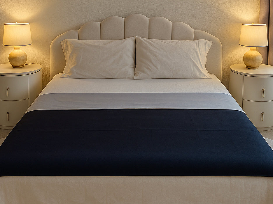Reversible Moonstone organic cotton Venus Mat on bed — soft grey certified organic cotton face and black active-dry waterproof backing, made in the USA