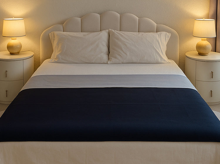 Reversible Moonstone organic cotton Venus Mat on bed — soft grey certified organic cotton face and black active-dry waterproof backing, made in the USA